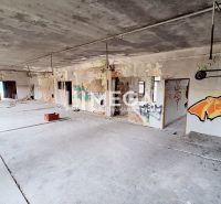 EXKLUZÍVNE NA PREDAJ budova na sídlisku 2A v meste Humenné - Opustený interiér budovy s graffiti a surovou betónovou podlahou.