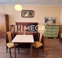 ZNÍŽENÁ CENA -  NA PREDAJ Dom v obci Kochanovce - Izba v rodinnom dome s podlahou s dreveným dekorom, stolom, stoličkami a starožitným nábytkom.