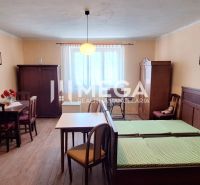 ZNÍŽENÁ CENA -  NA PREDAJ Dom v obci Kochanovce - Izba v rodinnom dome s dreveným dekorom, starožitným nábytkom a jednoduchým osvetlením.