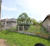 NA PREDAJ: Stavebný pozemok – Senné (okres Michalovce) - Pozemky - bývanie v Sennom s plotom a domami na pozadí.