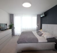 REZERVOVANÝ PRÉMIOVÝ 3-IZBOVÝ BYT S VÝHĽADOM 77 m² v Humennom - Spálňa v 3-izbovom byte s veľkou posteľou a komodou v sivých odtieňoch.