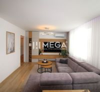 REZERVOVANÝ PRÉMIOVÝ 3-IZBOVÝ BYT S VÝHĽADOM 77 m² v Humennom - Obývacia izba v 3-izbovom byte s pohovkou, televízorom a podlahou s dreveným dekorom.