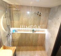 REZERVOVANÝ PRÉMIOVÝ 3-IZBOVÝ BYT S VÝHĽADOM 77 m² v Humennom - Kúpeľňa v 3-izbovom byte s podlahou s dreveným dekorom a skleneným sprchovým kútom.
