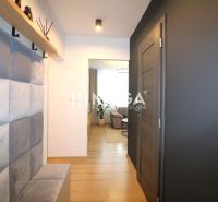 REZERVOVANÝ PRÉMIOVÝ 3-IZBOVÝ BYT S VÝHĽADOM 77 m² v Humennom - Chodba v 3-izbovom byte s podlahou s dreveným dekorom a vešiakom na stene.