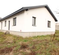 NA PREDAJ: 4-izbová NOVOSTAVBA v blízkosti Košíc - Rodinný dom v obci Vajkovce s bielou fasádou a šedou strechou na trávnatom pozemku.