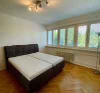 PRENÁJOM - 3-izbový byt priamo v centre Nitry s parkovaním a balkónom - Spálňa s veľkou posteľou a podlahou s dreveným dekorom v 3-izbovom byte.