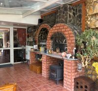 PREDAJ - 4-izbový luxusný rodinný dom s investičným pozemkom  - Tehlový krb v rodinnom dome s presklenou strechou a dekoratívnou stenou z kameňa.