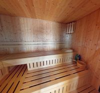 Veľkometrážny rodinný dom s investičným potenciálom - Sauna v rodinnom dome s drevenými lavicami a stenami, vedľa kachlí.