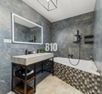 Moderný 4i dom v RED OAK, Lužianky | Kompletné zariadenie! - Kúpeľňa v rodinnom dome s vaňou, kamennými obkladmi a veľkým zrkadlom.