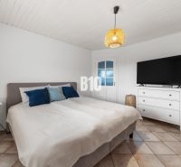 4i rodinný dom Lehota | 230 m² | Bazén | 85 m² garáž | 5 min. od Nitry - Spálňa v rodinnom dome s posteľou, televízorom a nočným stolíkom.