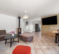 4i rodinný dom Lehota | 230 m² | Bazén | 85 m² garáž | 5 min. od Nitry - Obývacia izba v rodinnom dome s krbom a televízorom na kamennem obklade steny.