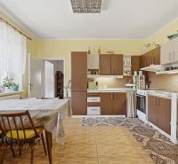 Na predaj 5-izb. dvojgen. rodinný dom, Dúbravica - Kuchyňa v rodinnom dome s klasickým zariadením, podlahou s dreveným dekorom a jedálenským stolom.
