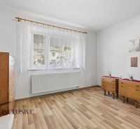 Na predaj 5-izb. dvojgen. rodinný dom, Dúbravica - Izba v rodinnom dome s podlahou s dreveným dekorom, nábytkom a bielymi závesmi.