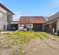Na predaj 5-izb. dvojgen. rodinný dom, Dúbravica - Dvor rodinného domu v Dúbravici s hospodárskymi budovami a psom na pozemku.