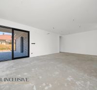 Na predaj 4-izb. rodinné domy s garážou, Hviezdoslavov - Priestranná miestnosť v rodinnom dome s betónovou podlahou, výhľad na terasu.