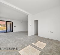 Na predaj 4-izb. rodinné domy s garážou, Hviezdoslavov - Prázdna miestnosť v rodinnom dome s výhľadom na záhradu cez veľké okno.