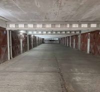 Garáž na ul. Chlumeckého, Ružinov - Garáže na Chlumeckého ulici v Bratislave - Ružinove s radovými železnými dverami.