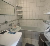 Na prenájom útulný 1,5-izbový byt na Okružnej ulici - Kúpeľňa v 2-izbovom byte s vaňou, umývadlom a práčkou, obložená bielymi dlaždicami.