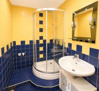 Predaj! slnečný 3-izbový byt s loggiou 74 m² Podbreziny - LM - Kúpeľňa v 3-izbovom byte s modro-žltými obkladačkami a sprchovacím kútom.