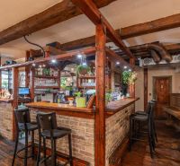 I Investičná reštaurácia v Starom Meste s nájomcom - Bar s tehličkovým obložením a drevenými trámami v gastro priestoroch, podlaha s dreveným dekorom.