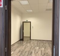 Kancelárske, obchodné a skladové priestory od 14m2 do 500m2 v areáli. - Prázdna miestnosť s bielymi stenami, stropnými svetlami a podlahou s dreveným dekorom.