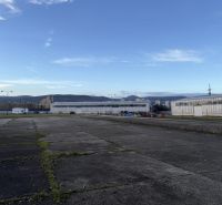 Sklad. priestory 200m2 - 1000m2, spevnené plochy do 6000m2 v areáli. - Exteriér skladov a hál v Bratislave - Rači so spevnenou plochou a horami v pozadí.