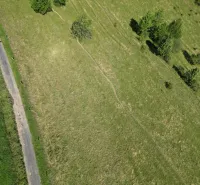 Vyšné Ružbachy – 1.016 m2 POZEMOK na CHATKU – Predaj - Letecká snímka krajiny pri Starej Ľubovni, zvýrazňujúca zelené lúky a stromovú scenériu.