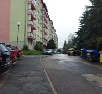 Predaj investičného pozemku. Podborová - Pohľad na bytovku a parkovisko na Ružovej ulici v Zvolene, obklopené stromami.