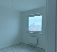 Nové skolaudované byty a apartmány vo Vajnoroch. - Izba s podlahou s dreveným dekorom v 2-izbovom byte, bielymi stenami a radiátorom.