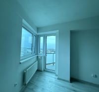 Nové skolaudované byty a apartmány v projekte Diamant. - Interiér 2-izbového bytu s podlahou s dreveným dekorom a výhľadom cez okno na mesto.