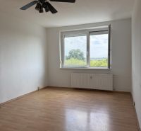 Kľúč RK-Novinka:Priestranný 2-iz.byt s loggiou.(možnosť zmeny na 3-iz) - Izba v 2-izbovom byte s podlahou s dreveným dekorom a stropným ventilátorom.