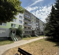 Kľúč RK-Novinka:Priestranný 2-iz.byt s loggiou.(možnosť zmeny na 3-iz) - Bytový dom na Čiližskej ulici v Bratislave-Vrakuni s lavičkou v popredí.