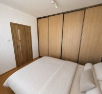 3-izb. byt (74m2), balkón, komora, Senica - Sotiná - Interiér spálne v 3-izbovom byte s podlahou s dreveným dekorom a veľkou skriňou.