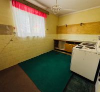 PREDAJ: 2i byt; 65 m2; CENTRUM - KRUPINA; 84.500 €  - Kuchyňa v 2-izbovom byte s lino podlahou a oknom so závesmi.