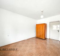 Na prenájom 5-izb. rod. dom s garážou, Vydrany - Izba v rodinnom dome s bielymi stenami, podlahou s dreveným dekorom a drevenou skriňou.
