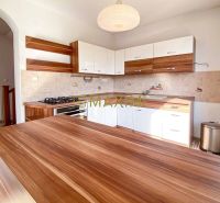 5-izbový rodinný dom, dvojpodlažný, podpivničený, Kátlovce - Kuchyňa v rodinnom dome s podlahou s dreveným dekorom a drevenými skrinkami.