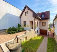 5-izbový rodinný dom, dvojpodlažný, podpivničený, Kátlovce - Rodinný dom v Kátlovciach s dláždeným chodníkom a garážou, obklopený zeleňou.