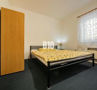APARTMÁNOVÝ DOM v Radave - 7 apartmánov na predaj - Spálňa v rodinnom dome s kovovou posteľou, skriňou a vzorovanou záclonou.