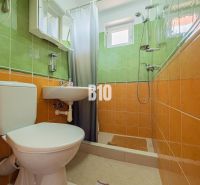 APARTMÁNOVÝ DOM v Radave - 7 apartmánov na predaj - Kúpeľňa v rodinnom dome s oranžovo-zelenými obkladmi a sprchovacím kútom.