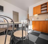 APARTMÁNOVÝ DOM v Radave - 7 apartmánov na predaj - Kuchyňa v rodinnom dome s tmavou dlažbou a drevenými skrinkami.