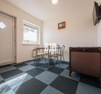 APARTMÁNOVÝ DOM v Radave - 7 apartmánov na predaj - Jedálenský kút v rodinnom dome s geometrickou podlahou a detskou postieľkou.