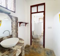 SAMOSTATNE STOJACA VILA MAPUMZIKO S 2 IZBAMI NA ZANZIBARE  - Kúpeľňa v rodinnom dome so zaujímavou mozaikovou umývadlovou doskou a oddeleným WC.