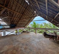 SAMOSTATNE STOJACA VILA MAPUMZIKO S 2 IZBAMI NA ZANZIBARE  - Rustikálna strecha na poschodí rodinného domu v Fumba Town s výhľadom na palmy.