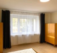 Prenájom 2-izbového bytu, Martin - centrum - Svetlá spálňa s veľkým oknom a podlahou s dreveným dekorom v 3-izbovom byte.
