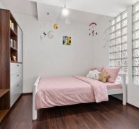 Apartmán vhodný na Airbnb aj rodinné bývanie | Vienna Gate - Detská izba s podlahou s dreveným dekorom, ružovou posteľou a svetlými stenami.