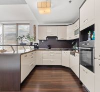 Apartmán vhodný na Airbnb aj rodinné bývanie | Vienna Gate - Kuchyňa v 3-izbovom byte s podlahou s dreveným dekorom a rohovou linkou.