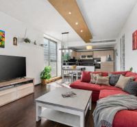 Apartmán vhodný na Airbnb aj rodinné bývanie | Vienna Gate - Obývacia izba s červeným rohovým gaučom, televízorom a kuchynským kútom v 3-izbovom byte.