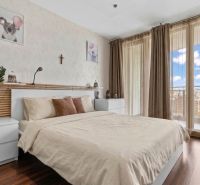 Apartmán vhodný na Airbnb aj rodinné bývanie | Vienna Gate - Svetlá spálňa s posteľou, podlahou s dreveným dekorom a výhľadom z 3-izbového bytu.