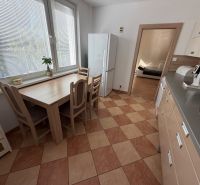 3 izbový byt s balkónom Topoľčany  - Kuchyňa v 3-izbovom byte s kachličkovou podlahou, jedálenským stolom a spotrebičmi.