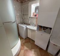 3 izbový byt s balkónom Topoľčany  - Kúpeľňa v 3-izbovom byte s práčkou, sprchovacím kútom a úložnými skrinkami.